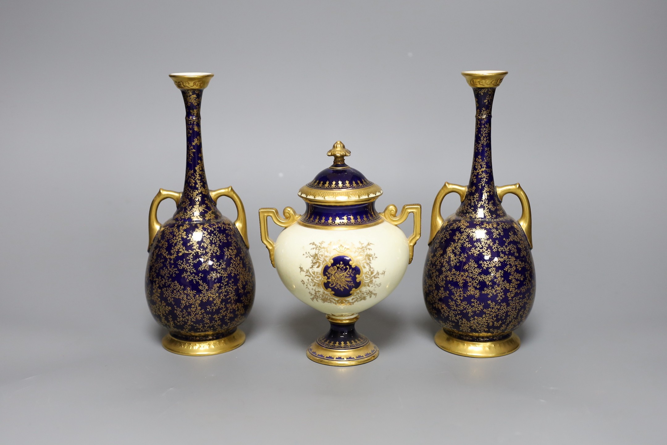 A pair of Royal Worcester bottle vases and a Coalport landscape vignette vase and cover, pair of vases 20 cms high